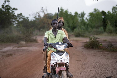 Members of a self-defence force (Koglweogo or bush guardians) on patrol on a motor scooter in the village of Poessin near Ouagadougou.  Once considered 'safe', Burkina Faso (meaning 'land of the uprig...