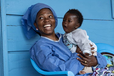 Joniste Kahambu, whose three-year-old son died of Ebola, with a child at the Butembo Ebola creche where she works as a so-called 'lullaby singer'.