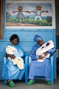 Yvette Katungy (L) and Gentile Kahunia (R), two so-called 'lullaby singers' who are ebola survivors and therefore have a level of immunity, looking after 25-day-old twins at the Butembo Ebola creche....