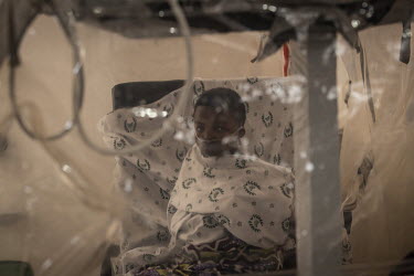 A woman in an isolation cube receives treatment at the Butembo Ebola Treatment Centre.