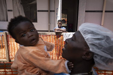 Ebola survivor Edwige Mate (24) in the recovery isolation ward at the Butembo Ebola Treatment Centre. Her son Aristote has been brought from the centre's creche to see her by a so-called 'lullaby sing...