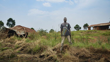 A worker in the grounds of the twice destroyed school in the village of Che.  There are at least 5.5 million internally displaced people (IDPs) in the DRC, mostly in the eastern provinces. In Ituri pr...