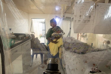 Ebola survivor Mwamini Masika (34) holding a two day old, unnamed baby, in an isolation facility. Masika caught the disease after handling the body of her dead nephew. A vaccination she received after...