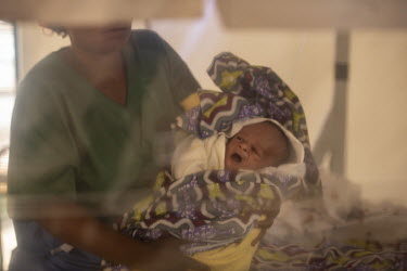 Ebola survivor Mwamini Masika (34) holding a two day old, unnamed baby, in an isolation facility. Masika caught the disease after handling the body of her dead nephew. A vaccination she received after...