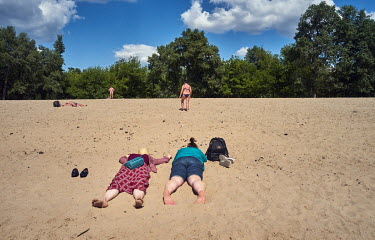 People relaxing on a sandy beach by the Dnipro River.