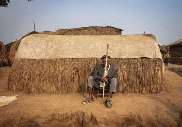 An elderly man sits outside a shelter made from thatch and a tarpaulin at an IDP where around 20,000 people are housed although they receive practically no aid.  There are at least 5.5 million interna...