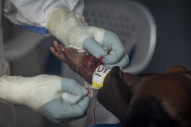 A medical worker tries to insert a cannula into a child being treated in an isolation cube at the Beni Ebola Treatment Centre. Ebola causes severe haemorrhaging which means that even simple medical pr...