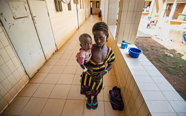 Mariam Diallo (7) holding her brother Bariessatta Diallo (5 months) at the Kaya Regional Hospital where he is being treated for malnutrition. The hospital is operating at over 100% capacity, in many c...