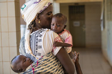 Oussuni Diallo holds her child Bariessatta Diallo (5 months) at the Kaya Regional Hospital where they are being treated for malnutrition. The hospital is operating at over 100% capacity, in many cases...