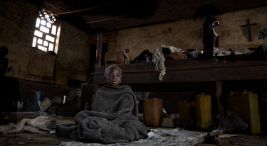 Salaman (10) sits, wrapped in a blanket, in a disused church along with several hundred other IDPs in Drodro where at least 20,000 displaced people are living.  There are at least 5.5 million internal...