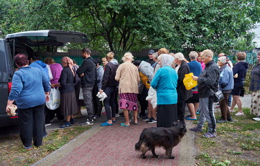 People waiting in a queue for food aid near the Mass Grave of Soldiers of the Soviet Army.