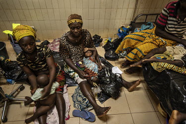 Women sit with children who are being treated in the Kaya Regional Hospital which is operating at over 100% capacity, in many cases there are three patients per bed.   Once considered 'safe', Burkina...