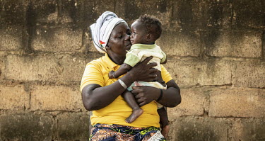 A woman embraces a child at Oasis des Enfants Orphanage, founded 1969.  Once considered 'safe', Burkina Faso (meaning 'land of the upright man') is suffering from increasing instability as a result of...