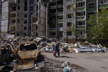 A man walks past a series of destroyed apartment blocks in a residential area was a hit by a Russian warplane on the 3 March 2022, killing 47 civilians.