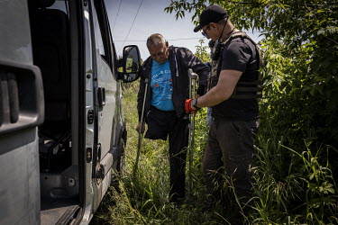 A volunteer with the NGO Vostok-SOS helps Mykhaylo Silichkin (62) on to a minibus during an evacuation mission. As Russian forces continue their offensive in eastern Ukraine, a range of mostly volunte...