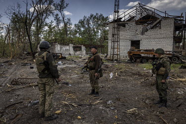 Ukrainian soldiers gathered near destroyed Russian armoured vehicles in a forested area near the Seversky Donets river. Earlier in May 2022, Ukrainian forces had inflicted heavy losses on a Russian ba...