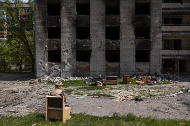 Halyna Gundareva (69) rests in front of the destroyed apartment block where her home was, after collecting what furniture and personal belongings she could salvage. The building and surrounding area w...