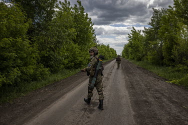 A Ukrainian soldier, carrying an anti-tank weapon, keeps watch while walking towards the recently recaptured village of Novopil.