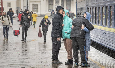 Couples from Mykolayiv say their goodbyes and embrace before the women board a Lviv bound train at Odessa's railway station.