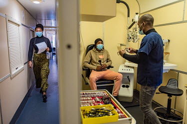 An optometry student carries out an eye test in one of the onboard consulting rooms on the Phelophepa healthcare train as dispensing optician Lundikazi Matinise (27, L) walks along the carriage. The t...