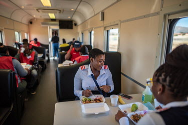 Medical staff and temporary workers eat lunch in the dining carriage onboard the Phelophepa healthcare train. The train has been providing primary health services to remote and under-resourced areas o...