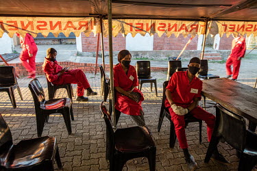 A team of cleaners on a temporary contract with the Phelophepa healthcare train wait for the medical staff to finish with the last of their patients in the evening before starting work. The train, whi...