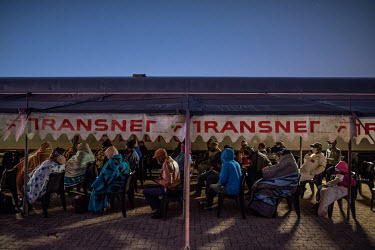 Patients, many of them wrapped in blankets to ward off the pre-dawn cold, sit on the patform of Thaba Nchu railway station as they wait to use the train's medical facilities. Many of the train's patie...