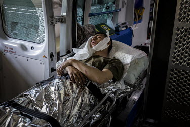 A Ukrainian soldier, who has shrapnel injuries to the head and abdomen, is loaded into an ambulance before being transferred to a hospital in Dnipro.