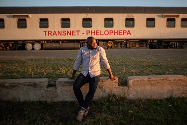 Bheki Mendlula, the manager of the Phelophepa healthcare train, watches the sunset from the platform of Thaba Nchu railway station. Mendlula first started working on the train as a student on a two we...