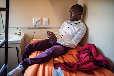 Malokho Makhita (23), an optometry student, checks his phone in his cabin before starting work in the eye clinic of the Phelophepa healthcare train. Makhita will spend two weeks on the train gaining e...
