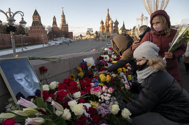 People lay flowers and anti-war posters during a memorial march at the site of the murder of Boris Nemtsov, killed on 27 February 2015 on the Moskyoretsky Bridge in front of the Kremlin and Red Square...