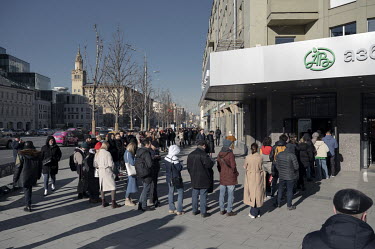 People stand in line waiting to use an ATM at a branch of the Tinkoff Bank in order to withdraw cash in Euros or US Dollars. Over 10 millions euros were withdrawn within a few days of Russia's invasio...