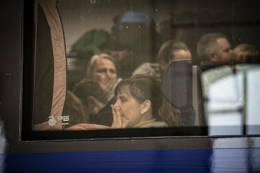A woman refugee looks out of train carriage window at Lviv Central railway station.