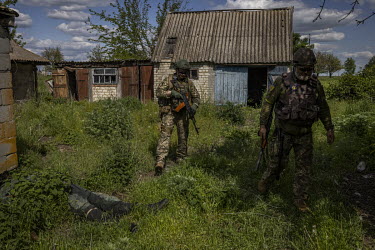 Colonel Oleksandr Ihatiev, commander of Zaporizhzhia territorial defence force, and a fellow soldier walk past the body of a Russian soldier in the recently recaptured village of Novopil.