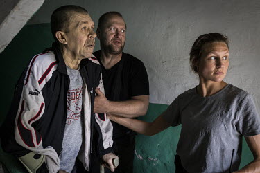 Volunteers from the UK and Ukraine, working with the NGO Vostok-SOS, pause in the doorway of Vadym Turchyn's apartment building during a barrage of seemingly nearby explosions. As Russian forces conti...