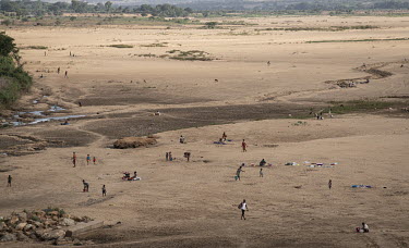 People dig holes in search of water in the dry Manambovo riverbed.