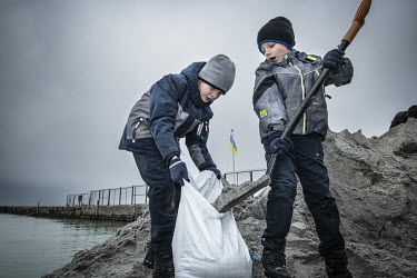Evgeny (8) and Roman (6) fill sandbags at the Black Sea Yacht club.