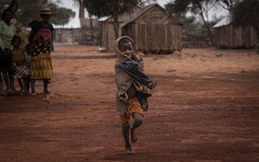 A child runs through the rain in Marofoty village. Although rain occasionally falls it is far too little, and much less than needed.