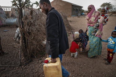 Mohamed unloads water containers from his wheel barrow. They must walk two kilometers to collect water. He came with his children and wife Waris from Ethiopia five weeks ago. ''We had 50 animals, now...