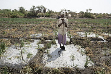 A villager stands in water from a well drilled to create an irrigation system that won't deplete the waters of Lake Chad but will help overcome the encroaching desert.  Lake Chad, which spanned 9,652s...
