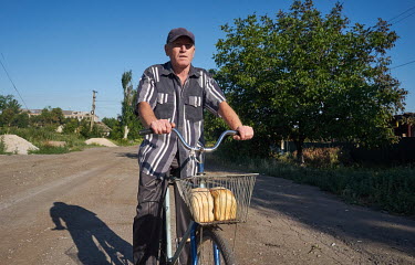 A man with two loaves of bread which he received from the Christian Church of Awakening who distributed loaves of bread and five litre canisters of drinking water to residents still remaining in Pavlo...