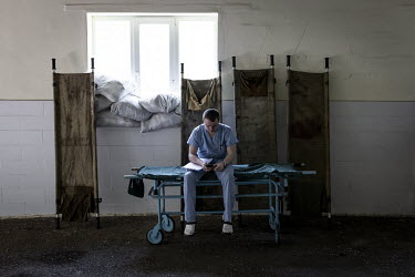 A medic rests on a stretcher outside a hospital in Kramatorsk, where wounded soldiers are treated before being transferred further west.