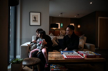 Eric Wong and Ann Hui play with their daughter Trini (4), in the lounge of the Sienna House apartment block where they live, after moving to the UK on British National Overseas visas. British governme...