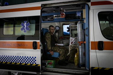 An injured Ukrainian soldier stares blankly while waiting in an ambulance to be transferred to another hospital further west.