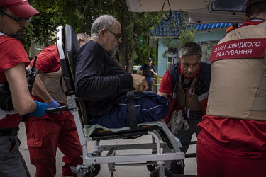 Medics with the Ukrainian Red Crescent lift a patient into an ambulance, during an operation to evacuate some long term patients from a hospital in Sloviansk.