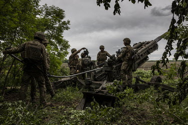 A gun crew of the 55th Separate Artillery Brigade of Ukraine's Armed Forces, load and prepare to fire a Howitzer M777 155mm Artillery piece towards Russian positions.