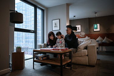 Eric Wong and Ann Hui play with their daughter Trini (4), in the lounge of the Sienna House apartment block where they live, after moving to the UK on British National Overseas visas. British governme...