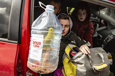 Refugees from Mauriupol arrive at a makeshift reception centre in a Zaporizhzhia supermarket car park with their budgie which they transported in an empty plastic water bottle.