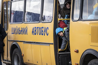 A boy looks out of a bus door which has brought refugees from Mauriupol to Zaporizhzhia.