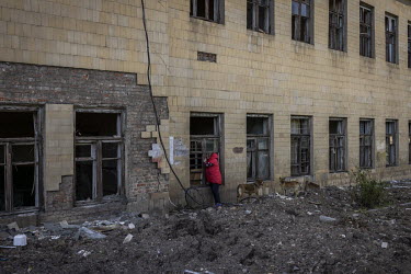 A woman delivers food to a friend who is living in a partially destroyed building that was damaged in a Russian strike.
